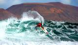 Surf-Profi Nic Muscroft beim „Islas Canarias Santa Pro 2009“ am Strand von San Juan auf Lanzarote – im Hintergrund die Nachbarinsel La Graciosa