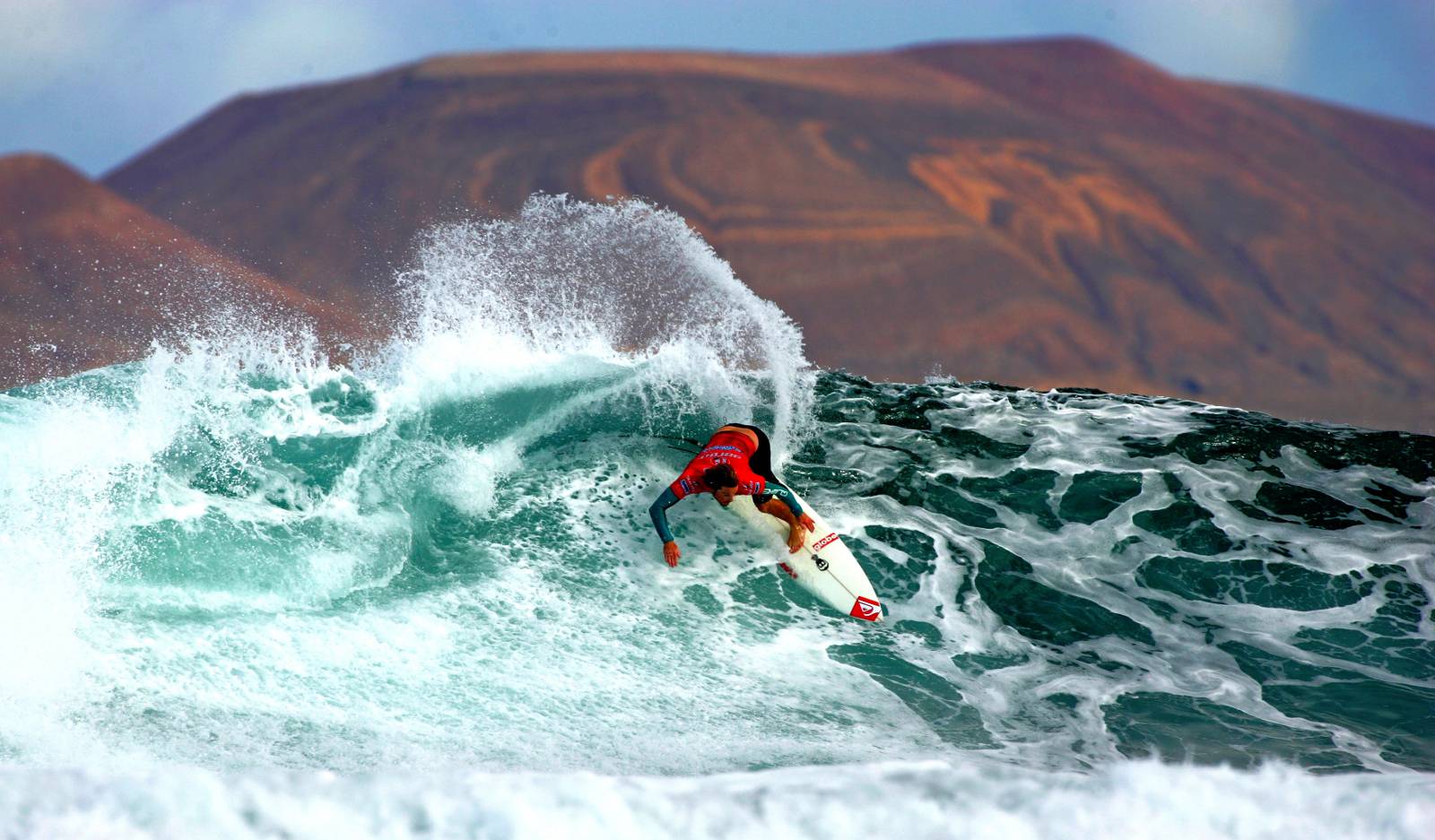 Surf-Profi Nic Muscroft beim „Islas Canarias Santa Pro 2009“ am Strand von San Juan auf Lanzarote – im Hintergrund die Nachbarinsel La Graciosa